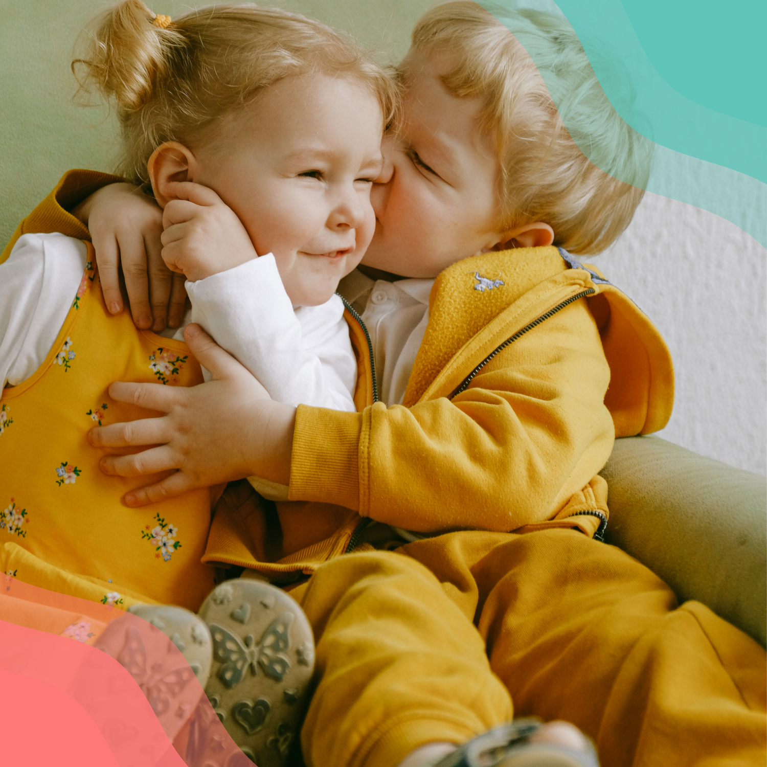 Young boy and girl dressed in yellow playfully hugging.